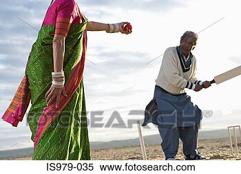 Stock Image - couple playing 
beach cricket. 
fotosearch - search 
stock photos, 
pictures, images, 
and photo clipart