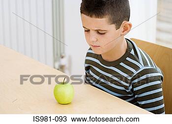 Stock Photo - boy frowning at 
apple. fotosearch 
- search stock 
photos, pictures, 
images, and photo 
clipart