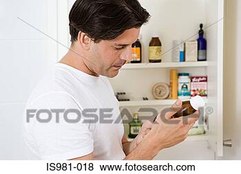 Stock Photo - man looking at 
label on cough 
medicine. fotosearch 
- search stock 
photos, pictures, 
images, and photo 
clipart