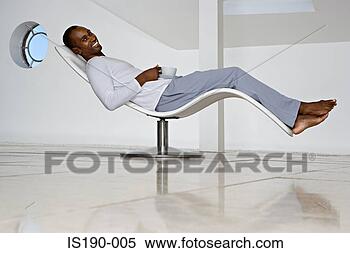 Stock Image - man relaxing in 
a curved chair. 
fotosearch - search 
stock photos, 
pictures, images, 
and photo clipart