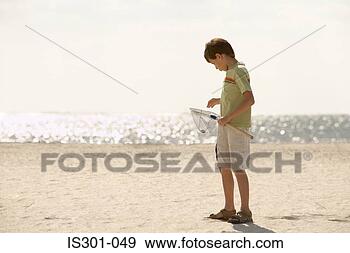 Stock Photograph - boy by sea with 
fishing net. fotosearch 
- search stock 
photos, pictures, 
images, and photo 
clipart