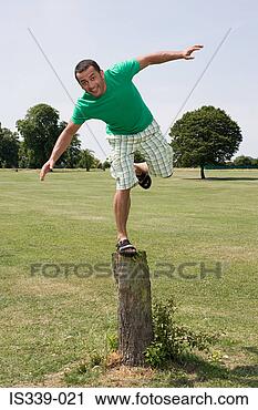 Stock Photography - man balancing 
on tree stump. 
fotosearch - search 
stock photos, 
pictures, images, 
and photo clipart