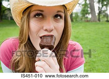 Arquivo de Fotografias - adolescente,  
menina,  comer, 
 gelo,  creme. 
fotosearch - busca 
de fotos, imagens 
e clipart
