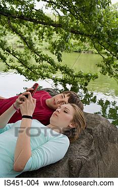 Banco de Imagem - adolescente,  
par,  usando, 
 celular,  telefone. 
fotosearch - busca 
de fotos, imagens 
e clipart
