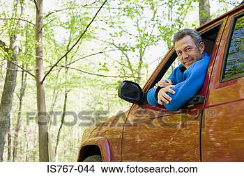 Stock Photo - man in an automobile 
in a forest. fotosearch 
- search stock 
photos, pictures, 
images, and photo 
clipart