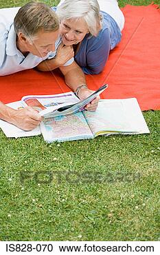 Stock Photography - couple looking 
at map and holiday 
brochure. fotosearch 
- search stock 
photos, pictures, 
images, and photo 
clipart