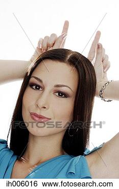 Stock Photo - woman making two 
horns with her 
fingers. fotosearch 
- search stock 
photos, pictures, 
images, and photo 
clipart