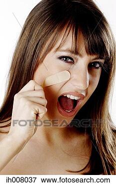 Picture - woman pulling 
out the plaster 
from her cheek. 
fotosearch - search 
stock photos, 
pictures, images, 
and photo clipart