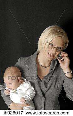 Picture - working mother 
talking on the 
mobile and carrying 
her baby. fotosearch 
- search stock 
photos, pictures, 
images, and photo 
clipart