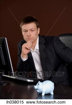 Stock Image - businessman in 
deep thought, 
focus on piggy 
bank. fotosearch 
- search stock 
photos, pictures, 
images, and photo 
clipart