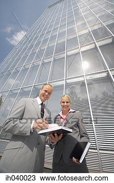 Stock Photo - businessman and 
businesswoman 
smiling at the 
camera. fotosearch 
- search stock 
photos, pictures, 
images, and photo 
clipart