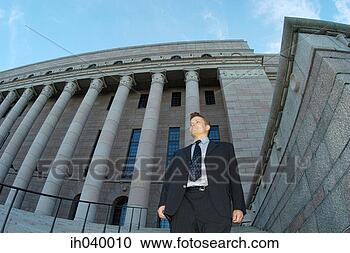 Stock Photography - businessman standing 
in front of a 
building. fotosearch 
- search stock 
photos, pictures, 
images, and photo 
clipart