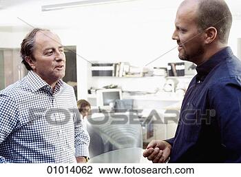 Stock Photo - two male office 
workers having 
a conversation 
in an open plan 
office. fotosearch 
- search stock 
photos, pictures, 
images, and photo 
clipart