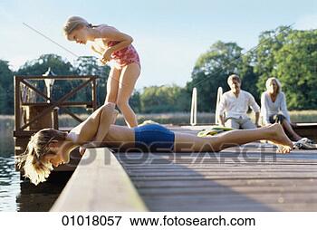 Picture - two children peering 
into a lake as 
their parents 
look on. fotosearch 
- search stock 
photos, pictures, 
images, and photo 
clipart