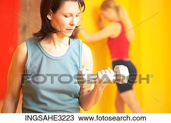 Stock Photo - mature adult woman 
lifting weights 
with woman stretching 
in background. 
fotosearch - search 
stock photos, 
pictures, images, 
and photo clipart