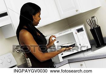 Stock Photography - a woman placing 
a dish in a microwave 
oven. fotosearch 
- search stock 
photos, pictures, 
images, and photo 
clipart