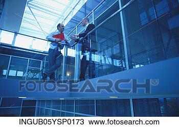 Stock Photo - low angle view 
of two businessmen 
talking on a landing. 
fotosearch - search 
stock photos, 
pictures, images, 
and photo clipart