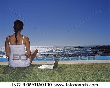 Stock Photography - rear view of a 
young woman sitting 
on a lawn. fotosearch 
- search stock 
photos, pictures, 
images, and photo 
clipart