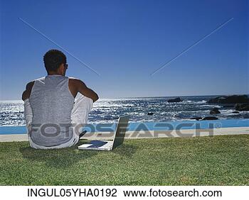 Stock Photo - rear view of a 
young man sitting 
on a lawn. fotosearch 
- search stock 
photos, pictures, 
images, and photo 
clipart