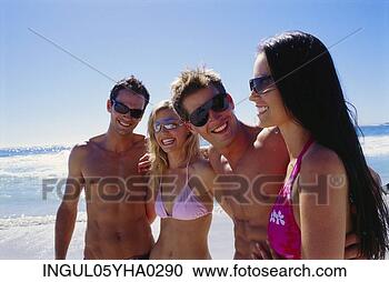 Stock Photography - two young couples 
standing on the 
beach. fotosearch 
- search stock 
photos, pictures, 
images, and photo 
clipart