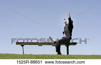 Stock Photography - businessman is 
waving his hands 
in celebration 
as he sits on 
a park. fotosearch 
- search stock 
photos, pictures, 
images, and photo 
clipart