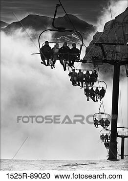Stock Photography - low angle view 
of tourists riding 
a ski lift. fotosearch 
- search stock 
photos, pictures, 
images, and photo 
clipart