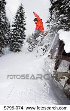 Stock Photo - man snowboarding 
off roof. fotosearch 
- search stock 
photos, pictures, 
images, and photo 
clipart