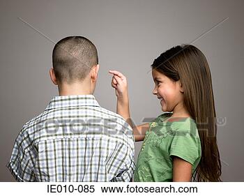 Stock Image - girl about to 
poke boy in ear. 
fotosearch - search 
stock photos, 
pictures, images, 
and photo clipart