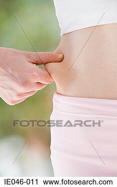 Stock Photography - woman pinching 
her stomach. fotosearch 
- search stock 
photos, pictures, 
images, and photo 
clipart
