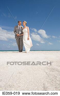 Stock Photograph - mature couple 
walking along 
the beach. fotosearch 
- search stock 
photos, pictures, 
images, and photo 
clipart