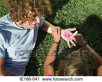 Stock Photography - young couple writing 
love on hands. 
fotosearch - search 
stock photos, 
pictures, images, 
and photo clipart