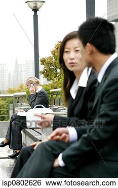 Stock Photo - a woman talking 
on the handphone 
while a couple 
chatting on the 
other. fotosearch 
- search stock 
photos, pictures, 
images, and photo 
clipart