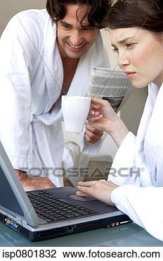 Stock Photo - a woman in bathrobe 
using laptop while 
her husband watching. 
fotosearch - search 
stock photos, 
pictures, images, 
and photo clipart