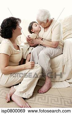 Stock Photograph - an old woman hugging 
her grandson while 
her daughter watching. 
fotosearch - search 
stock photos, 
pictures, images, 
and photo clipart