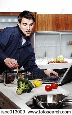 Stock Photograph - man cooking,  
using laptop and 
talking on the 
handphone at the 
same. fotosearch 
- search stock 
photos, pictures, 
images, and photo 
clipart