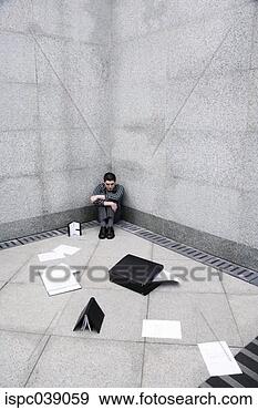 Stock Photograph - depressed businessman 
sitting at the 
corner of a building. 
fotosearch - search 
stock photos, 
pictures, images, 
and photo clipart
