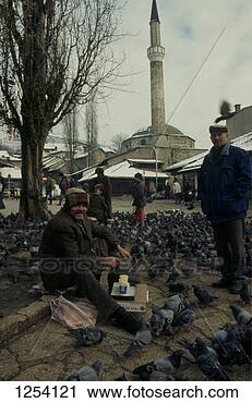 Stock Photography - man selling bird 
food outside the 
mosque in the 
old town location:. 
fotosearch - search 
stock photos, 
pictures, images, 
and photo clipart