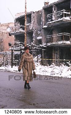 Stock Image - a woman walking 
past buildings 
damaged during 
the civil war 
location:. fotosearch 
- search stock 
photos, pictures, 
images, and photo 
clipart