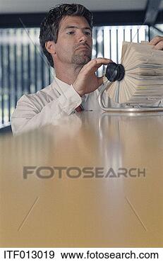 Stock Photograph - business man searching 
through a rotary 
file. fotosearch 
- search stock 
photos, pictures, 
images, and photo 
clipart