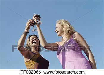 Stock Image - two women raising 
wine glasses standing 
outdoors. fotosearch 
- search stock 
photos, pictures, 
images, and photo 
clipart
