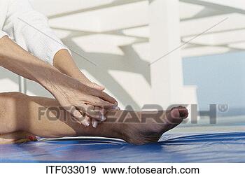 Stock Photograph - close-up of a 
mature woman stretching 
on an exercise 
mat. fotosearch 
- search stock 
photos, pictures, 
images, and photo 
clipart