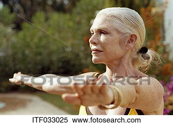 Stock Image - close-up of a 
mature woman practising 
yoga outdoors. 
fotosearch - search 
stock photos, 
pictures, images, 
and photo clipart