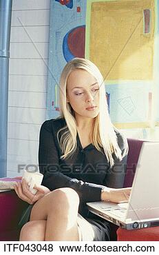 Stock Photo - woman sitting 
having a warm 
drink using a 
laptop computer. 
fotosearch - search 
stock photos, 
pictures, images, 
and photo clipart