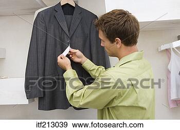 Stock Photograph - man looking at 
tags on jacket. 
fotosearch - search 
stock photos, 
pictures, images, 
and photo clipart