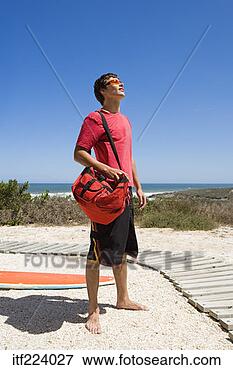 Picture - man with surfboard 
next to beach. 
fotosearch - search 
stock photos, 
pictures, images, 
and photo clipart