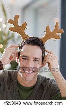 Stock Photo - smiling man wearing 
antlers. fotosearch 
- search stock 
photos, pictures, 
images, and photo 
clipart