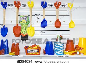 Stock Photo - hanging shovels 
over beach pales. 
fotosearch - search 
stock photos, 
pictures, images, 
and photo clipart