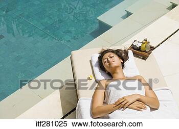 Stock Image - woman lying by 
swimming pool. 
fotosearch - search 
stock photos, 
pictures, images, 
and photo clipart