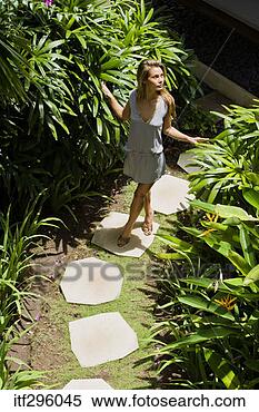 Stock Image - woman walking 
on stepping stones. 
fotosearch - search 
stock photos, 
pictures, images, 
and photo clipart