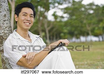 Picture - man with a book 
outdoors. fotosearch 
- search stock 
photos, pictures, 
images, and photo 
clipart